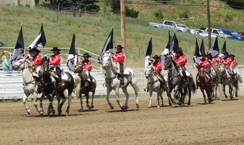 Members of the Westernaires ride into the Evergreen rodeo grounds in July during a show.